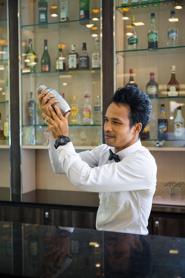 Aiyara Palace Pattaya Exterior photo A bartender shaking a cocktail
